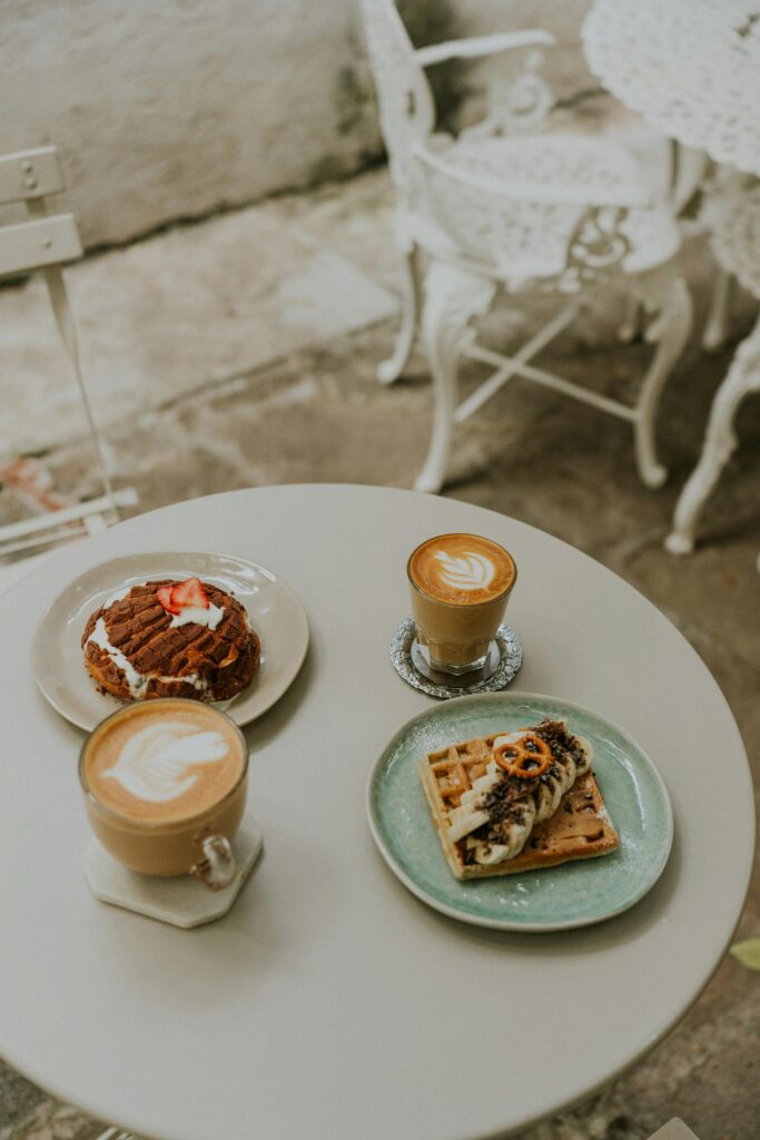 A table with two plates of food and coffee
